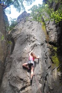 Kaya tırmanışı yapan kadın sporcu Datça kayalıklarında tırmanıyor.